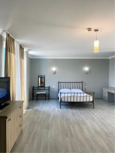 sypialnia z łóżkiem i telewizorem z płaskim ekranem w obiekcie Argo Hotel w mieście Ureki
