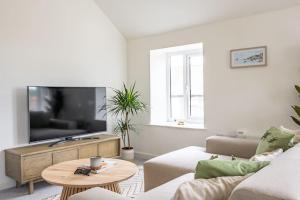uma sala de estar com um sofá e uma televisão em Newport Ship's Nook: Cozy Hideaway em Newport