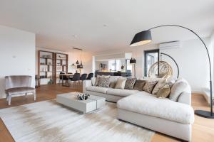 een woonkamer met een witte bank en een tafel bij BizStay Harbour III Scheveningen Apartments in Scheveningen