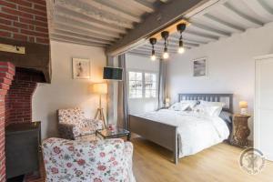 1 dormitorio con 1 cama y 1 silla en La Maisonnette en Saint-Pierre-sur-Dives