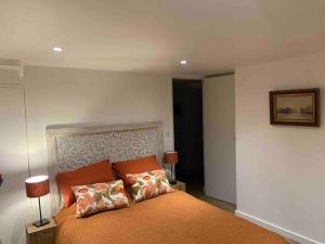 ein Schlafzimmer mit einem orangenen Bett mit zwei Kissen in der Unterkunft Maison à Saint Briac chez Delphine in Saint-Briac-sur-Mer