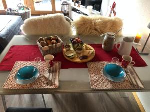 a table with two plates and a tray of food at Hop in Nest Cozy B&B in Wengen in Wengen