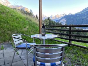 uma mesa e cadeiras em um pátio com vista para as montanhas em Bed & Breakfast in car-free Wengen - Hop in Nest BnB em Wengen