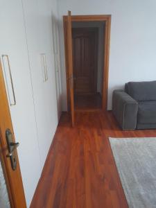 een woonkamer met een bank en een houten vloer bij Victoria Apartment Luxury in Târgu Jiu