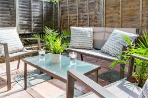 um pátio com uma mesa, cadeiras e plantas em West Lodge- Cosy home from home with 3 bedrooms em Worthing