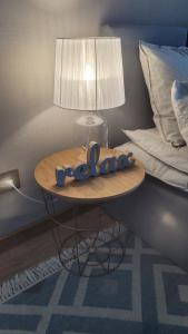a table in a bedroom with a lamp and a bed at Apartament Poleska Park in Częstochowa
