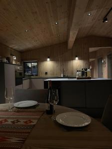 een keuken met een tafel met borden en wijnglazen bij New mountain lodge - Geilo-Kikut - Great location in Geilo