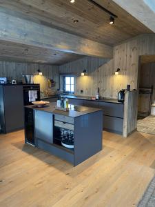 eine große Küche mit schwarzen Arbeitsplatten und Holzböden in der Unterkunft New mountain lodge - Geilo-Kikut - Great location in Geilo