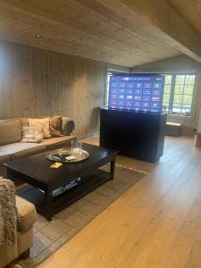 ein Wohnzimmer mit einem Sofa und einem Couchtisch in der Unterkunft New mountain lodge - Geilo-Kikut - Great location in Geilo