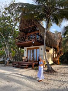 a woman standing in front of a house on the beach at Gaelia in Santa Marta