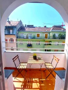 stół i krzesła na balkonie z budynkiem w obiekcie Black Sheep Budapest Smart Rooms w Budapeszcie