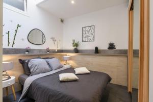 ein Schlafzimmer mit einem Bett mit zwei Kissen darauf in der Unterkunft Zenitude - Casa Vostra - Thonon Centre et Thermes in Thonon-les-Bains
