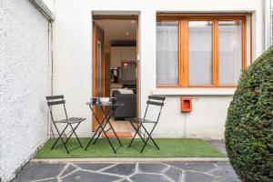 dos sillas y una mesa frente a una casa en Zenitude - Casa Vostra - Thonon Centre et Thermes, en Thonon-les-Bains