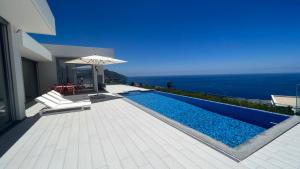 a villa with a swimming pool with a view of the ocean at Villa Camacho V - Luxurious Villa in Estreito da Calheta