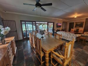 a living room with a wooden table and chairs at Riverrun Resort Farmhouse in Tygerfontein