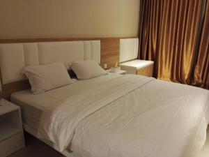 1 dormitorio con 1 cama grande con sábanas blancas en Free Shuttle Thamrin City Apartments at Nagoya with Netflix & Youtube Premium by MESA en Nagoya