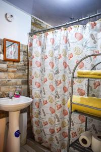 een badkamer met een douchegordijn en een wastafel bij CAPRICHOS Rooms in Tamarindo
