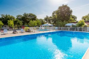 une grande piscine d'eau bleue dans l'établissement Mobil-home Andernos Les Bains 4pers, à Andernos-les-Bains