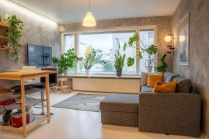 a living room with a couch and a table and a window at Arctic Circle Retreat: Stylish 2-Room Apartment in Rovaniemi