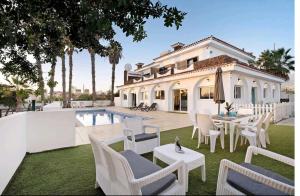a white house with a pool and chairs and a table at Villa Teide in Santiago del Teide