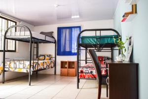 Zimmer mit 2 Etagenbetten und einem Schreibtisch in der Unterkunft CAPRICHOS Rooms in Tamarindo