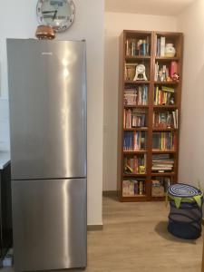 a stainless steel refrigerator in a room with a book shelf at Il mare a due passi in Civitanova Marche