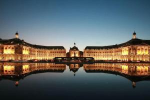 a large building with its reflection in the water at Maison de charme au pays du vin - Charming House in Wine Country in Montcaret