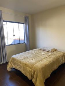 1 dormitorio con cama y ventana grande en Sobrado em condomínio fechado, en Carambeí