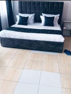 ein großes Bett mit schwarzweißer Bettwäsche und Kissen in der Unterkunft Peaceful Palace in Kisumu