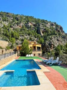 une maison avec une piscine en face d'une montagne dans l'établissement Casas Rurales Mirador del Rio Zumeta, à Santiago de la Espada