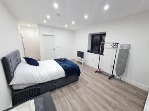 Homestay by BIC Legends 5 في Batley Carr: غرفة نوم فيها سرير وتلفزيون
