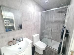 a bathroom with a shower and a toilet and a sink at Homestay by BIC Legends 5 in Batley Carr