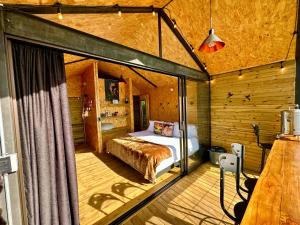 a bedroom in a log cabin with a bed at Caralsol Glamping in Rionegro