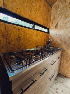 cocina con fogones y ventana en Caralsol Glamping, en Rionegro