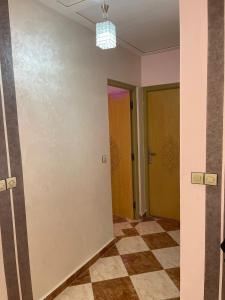 an empty hallway with two doors and a checkered floor at Luxurious appartement in Oujda