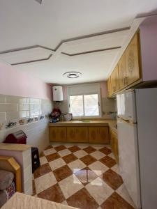 a kitchen with a checkered floor and a window at Luxurious appartement in Oujda