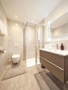 een badkamer met een douche, een wastafel en een toilet bij Gästehaus Kulmer in Hopfgarten im Brixental