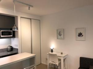 ein kleines Apartment mit einem Tisch und einer Küche in der Unterkunft Minimal Apartament in Palermo Soho in Buenos Aires
