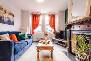 uma sala de estar com um sofá azul e uma lareira em West Lodge- Cosy home from home with 3 bedrooms em Worthing