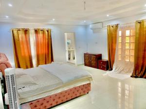 1 dormitorio con 1 cama en una habitación con ventanas en Résidence Toubab en Toubab Dialaw