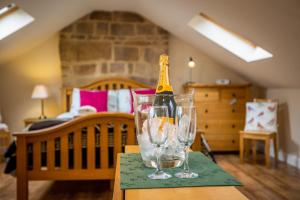 Una botella de champán en una copa sobre una mesa en Birds Nest, Romantic getaway with stunning views, en Matlock