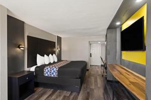 a hotel room with a bed and a flat screen tv at Scottish Inns Austin Downtown in Austin