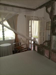 1 dormitorio con cama con dosel y ventana en Sophia house, en Malindi
