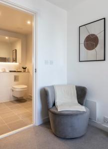 a living room with a chair and a toilet at Premium Apartments at Copper House in Liverpool City Centre in Liverpool