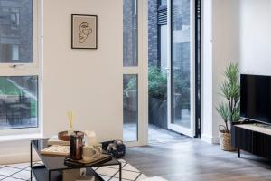 a living room with large windows and a tv at Premium Apartments at Copper House in Liverpool City Centre in Liverpool