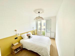 Un dormitorio con una cama blanca grande y una ventana en Cosy Saussier - Confort - Ideal Place, en Troyes