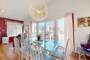 a dining room with a glass table and chairs at Villa Del Mar in Corolla