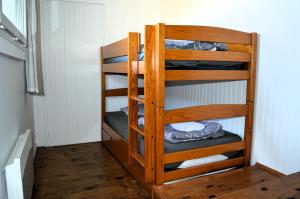 a wooden bunk bed in a room at La maison de la plage, à 350m de la mer, jardin in Asnelles