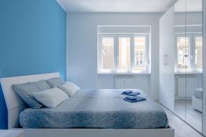 una camera blu con un letto con scarpe sopra di [Fibra SuperFast] Politeama Rossetti Modern Suite a Trieste