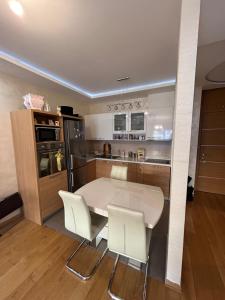 a kitchen with a white table and white chairs at Central Garden modern 1 bedroom condominium complex in Belgrade